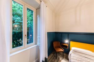 a bedroom with a window and a bed and a chair at ReGo Holiday Apartments City Center in Bergamo