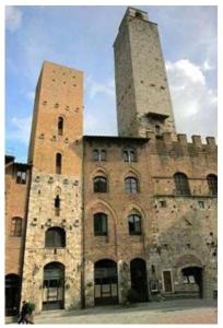 un antiguo edificio con dos torres encima en La Torre Useppi, en San Gimignano