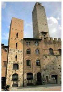 an old building with two towers on top of it at La Torre Useppi in San Gimignano