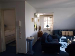 a living room with a blue couch and a bed at Haus am Meer in Cuxhaven