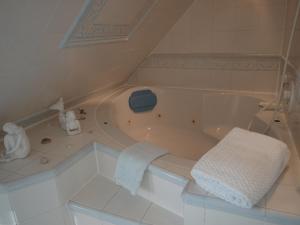 a white bath tub in a white tile bathroom at Haus am Meer in Cuxhaven