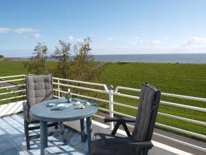 uma mesa e duas cadeiras numa varanda com o oceano em Haus am Meer em Cuxhaven