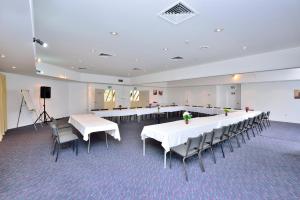 a large room with tables and chairs and a stage at Manukau Hotel & Conference Centre in Auckland