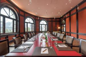 a long table in a room with windows at Hotel Schweizerhof St. Moritz in St. Moritz