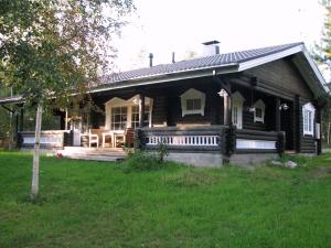 a wooden house with a porch and a deck at Villa Mertala in Pääjärvi