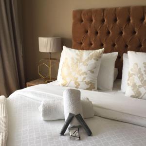 una camera da letto con letto, lenzuola e cuscini bianchi di 23 on Camden Guest House a East London