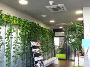 una pared verde en una oficina con plantas en Study Hôtel Bordeaux Lormont en Lormont