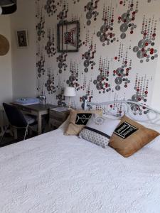 a bedroom with a white bed with a wall with beads at Proximite circuit 24 heures in Le Mans