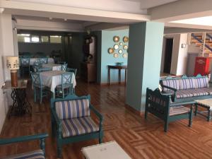 ein Esszimmer mit Stühlen und Tischen und ein Zimmer mit blauen Wänden in der Unterkunft Knossos Hotel in Tolo