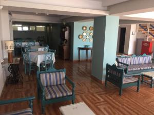 a dining room with chairs and tables and a room with blue walls at Knossos Hotel in Tolo