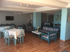 ein Wohnzimmer mit Stühlen, einem Tisch und einem Sofa in der Unterkunft Knossos Hotel in Tolo