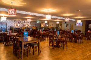 ein Restaurant mit Holztischen und Stühlen und Lichtern in der Unterkunft Camping Pods, Golden Sands Holiday Park in Dawlish