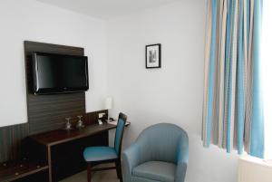 a room with a desk and a chair and a tv at Konoba in Meckenheim