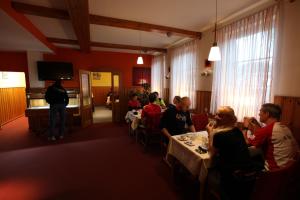 Hotel garni Harzer Hof في أوسترود: مجموعة من الناس يجلسون على طاولة في غرفة