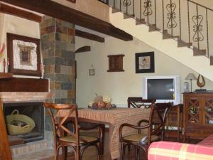 a living room with a table with chairs and a fireplace at La Tiná in Segura de la Sierra