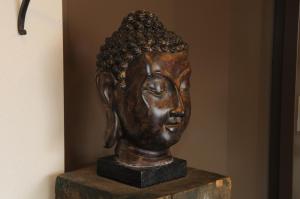 uma estátua da cabeça de bronze sentada num bloco de madeira em Hôtel du Moulin em Niort
