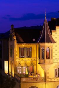 a yellow building with people on a balcony at night at Hotel Sant Roc in Solsona