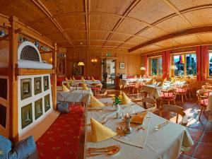 uma sala de jantar com mesas e cadeiras brancas em Steinbach-Hotel em Ruhpolding