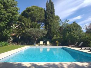 a swimming pool in a yard with trees at l appentis du chai in Roujan