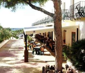 a group of tables and chairs in front of a building at Hotel Stella Del Sud in Calasetta