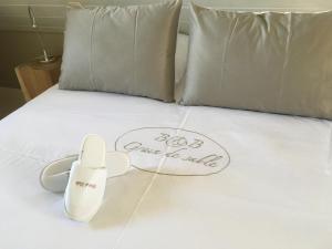 a bed with a pair of white shoes on it at B&B Grain de Sable in Knokke-Heist