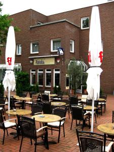 an outdoor patio with tables and chairs and umbrellas at Konoba in Meckenheim