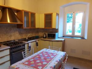 a kitchen with a table and a stove and a window at Casa Caterina in La Spezia