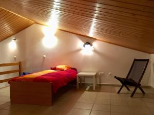 een slaapkamer met een bed, een stoel en verlichting bij Casa Trinta - Praia da Arrifana in Praia da Arrifana