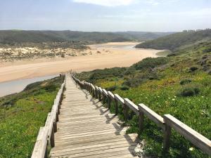 a wooden boardwalk leading down to a beach at Casa Trinta - Praia da Arrifana in Praia da Arrifana +6 photos