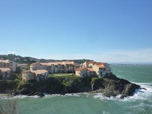 un grupo de casas en una isla rocosa en el océano en Apartment Les Roches Bleues-1 by Interhome en Collioure