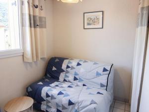 a bedroom with a bed with a blue comforter at Apartment Les Roches Bleues-2 by Interhome in Collioure