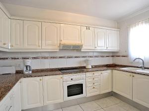 a white kitchen with white cabinets and a sink at Holiday Home Montemar by Interhome in Fanadix