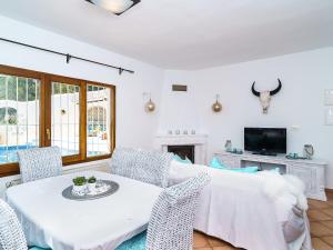 ein Wohnzimmer mit einem Tisch und Stühlen sowie einem TV in der Unterkunft Holiday Home Benimeit by Interhome in Moraira