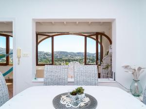 een eetkamer met een tafel en stoelen en een raam bij Holiday Home Benimeit by Interhome in Moraira