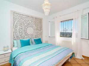 een witte slaapkamer met een bed en een kroonluchter bij Holiday Home Benimeit by Interhome in Moraira