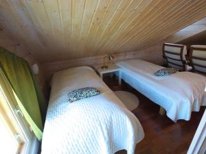 ユッラスヤルヴィにあるHoliday Home Ylläs iisakki as- 10a by Interhomeのベッド2台、テーブル、椅子が備わる客室です。