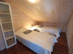 ユッラスヤルヴィにあるHoliday Home Ylläs iisakki as- 10a by Interhomeの木造キャビン内のベッド2台が備わる部屋