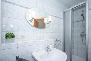a bathroom with a sink and a mirror at Ferienwohnungen beim Fischer und sin Fru in Klein Zicker