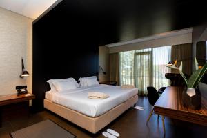 a hotel room with a bed and a large window at Evidencia Belverde Hotel in Charneca