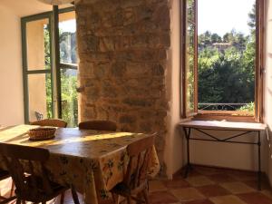 a dining room with a table and two windows at The Balcony Gîte - Riverside Lagrasse in Lagrasse +38 photos