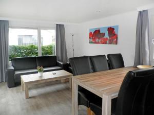 a living room with black chairs and a wooden table at Holiday Home Camping Cassandria Bad-1 by Interhome in Retranchement