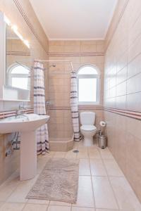 a bathroom with a sink and a toilet and a window at Lina's Amazing House in Ialysos in Ixia