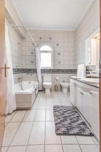 a bathroom with a tub and a toilet and a sink at Lina's Amazing House in Ialysos in Ixia