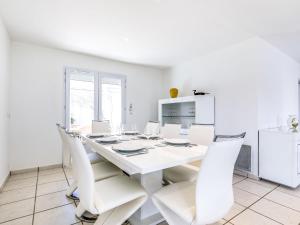 uma sala de jantar branca com uma mesa e cadeiras brancas em Holiday Home Villa Languedoc by Interhome em Saint-Palais-sur-Mer