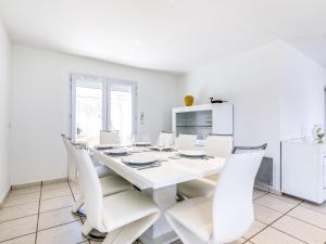 Un comedor blanco con una mesa y sillas blancas. en Holiday Home Villa Languedoc by Interhome, en Vaux-sur-Mer