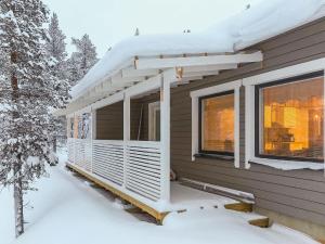 a house with a deck in the snow at Holiday Home Hilla a by Interhome in Saariselka