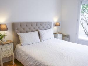 Un dormitorio con una gran cama blanca con dos lámparas. en Holiday Home Villa Languedoc by Interhome, en Vaux-sur-Mer