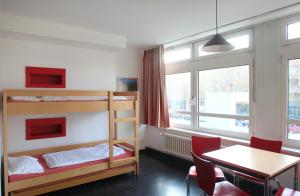 a bedroom with bunk beds and a table and a dining room at Jugendherberge-Berlin-International in Berlin