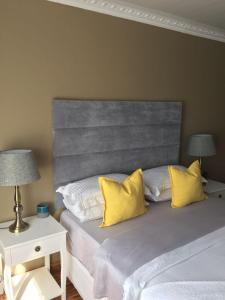 - une chambre avec 2 lits et des oreillers jaunes dans l'établissement 23 on Camden Guest House, à East London