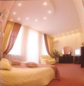 a bedroom with a large bed and a large window at Astoria Hotel in Dnipro